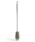 Gray silicone kitchen brush with a long handle on a white background