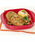 Red food container with meat patties, potato, and vegetables on a white background