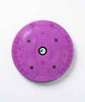 A purple circular balance board with textured footprints, wavy patterns, and small black weight plates, photographed from directly above on a white background.