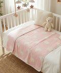 Crib with pink blanket and teddy bear in a nursery setting