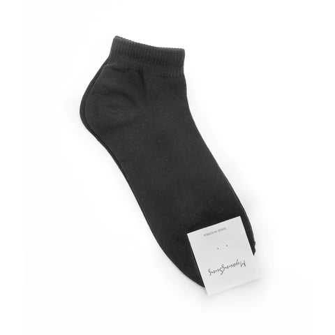 Black ankle sock with a white label on a white background