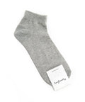 Gray ankle sock with a white label on a white background