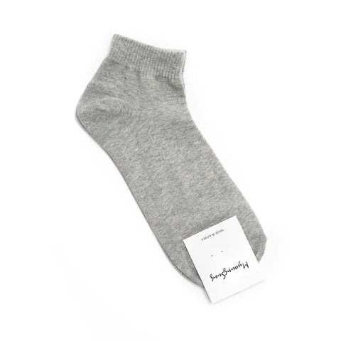 Gray ankle sock with a white label on a white background