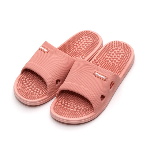 Pair of pink massage slippers on a white background