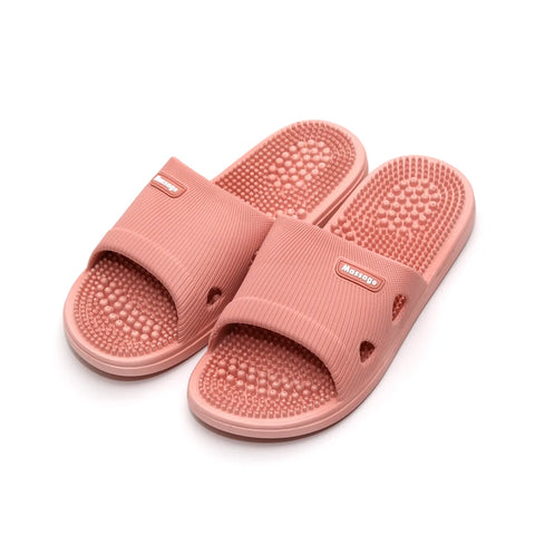 Pair of pink massage slippers on a white background