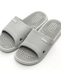 Gray massage slippers with acupressure balls on a white background