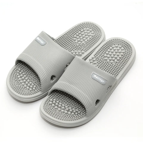 Gray massage slippers with acupressure balls on a white background