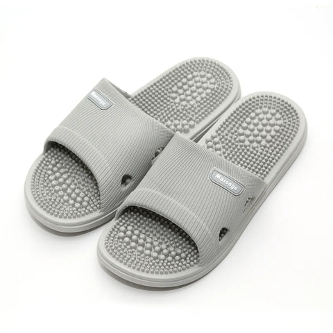 Pair of gray acupressure slippers on a white background