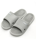 Pair of gray slippers with acupressure balls on a white background