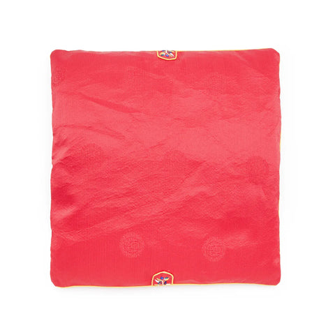 Red square seat cushion with an embroidered design on a white background