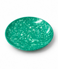 A small round green plate with a white speckled pattern, photographed on a white background.