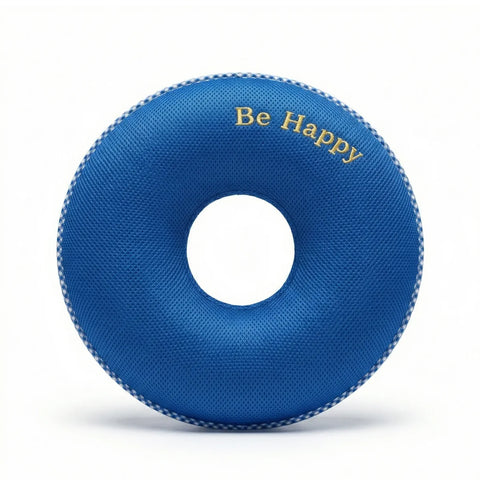 Blue donut-shaped pillow with 'Be Happy' text on a white background