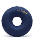 Circular navy blue donut cushion with 'Be Happy' text on a white background