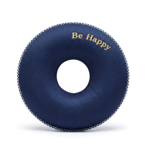 Circular navy blue donut cushion with 'Be Happy' text on a white background