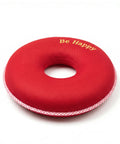 Red donut-shaped pillow with 'Be Happy' text on a white background