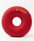 Red donut-shaped pillow with 'Be Happy' text on a white background