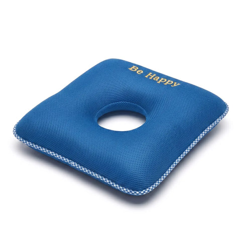 Blue donut pillow with 'Be Happy' text on a white background