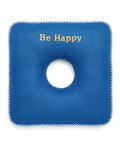 Blue donut cushion with a circular hole and 'Be Happy' text on a white background