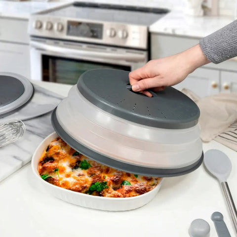Person placing a gray and clear microwave food cover on a dish of food on a kitchen counter.