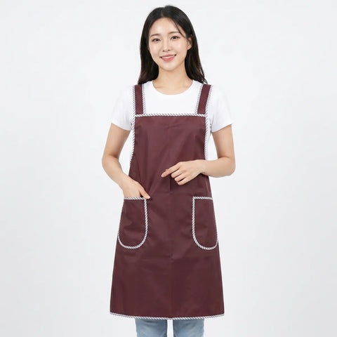 Woman wearing a maroon apron with white trim on a white background