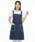 Person wearing a navy blue apron with white trim on a white background