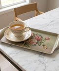Teacup and saucer on a floral tray on a marble table