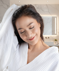 Woman wrapped in a white towel in a bathroom setting