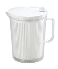 Clear salad spinner with handle and white lid on a white background