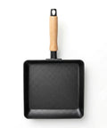 Black square frying pan with a wooden handle on a white background