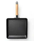 Black square frying pan with a wooden handle on a white background