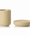 Beige ceramic cup and soap dish on a white background