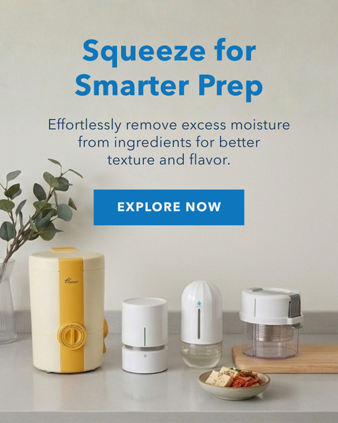 A countertop scene showing several small kitchen appliance containers in white and yellow, with a small bowl of ingredients on a wooden board. Large text reads 'Squeeze for Smarter Prep' with a blue 'EXPLORE NOW' button on a light gray background.