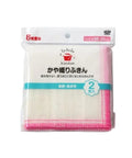 Packaged kitchen cleaning cloth set in Japanese, showing a white mesh cloth with pink stitched edges inside a clear plastic bag with printed branding and product details.