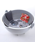A gray and white plastic spin wheel colander with a dark gray drain cover and a red tomato-patterned bag inside, photographed on a white background.
