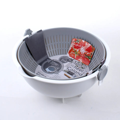 A gray and white plastic spin wheel colander with a dark gray drain cover and a red tomato-patterned bag inside, photographed on a white background.