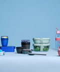 Set of reusable containers and bottles on a light blue background