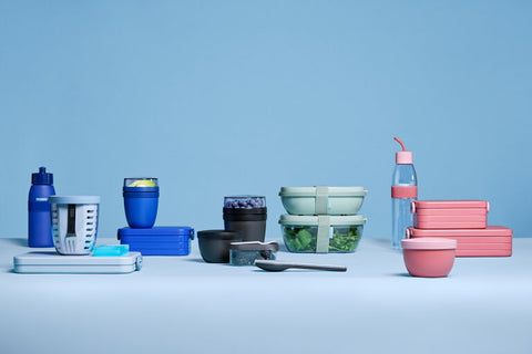 Set of reusable containers and bottles on a light blue background